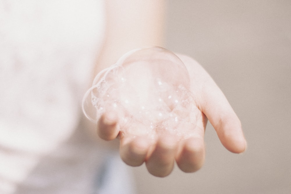 person holding bubbles from hand soap