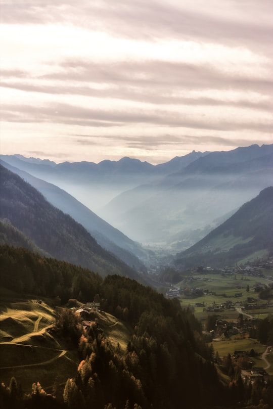 black mountains surrounded by trees under brown sky during daytime in Ahrntal Italy