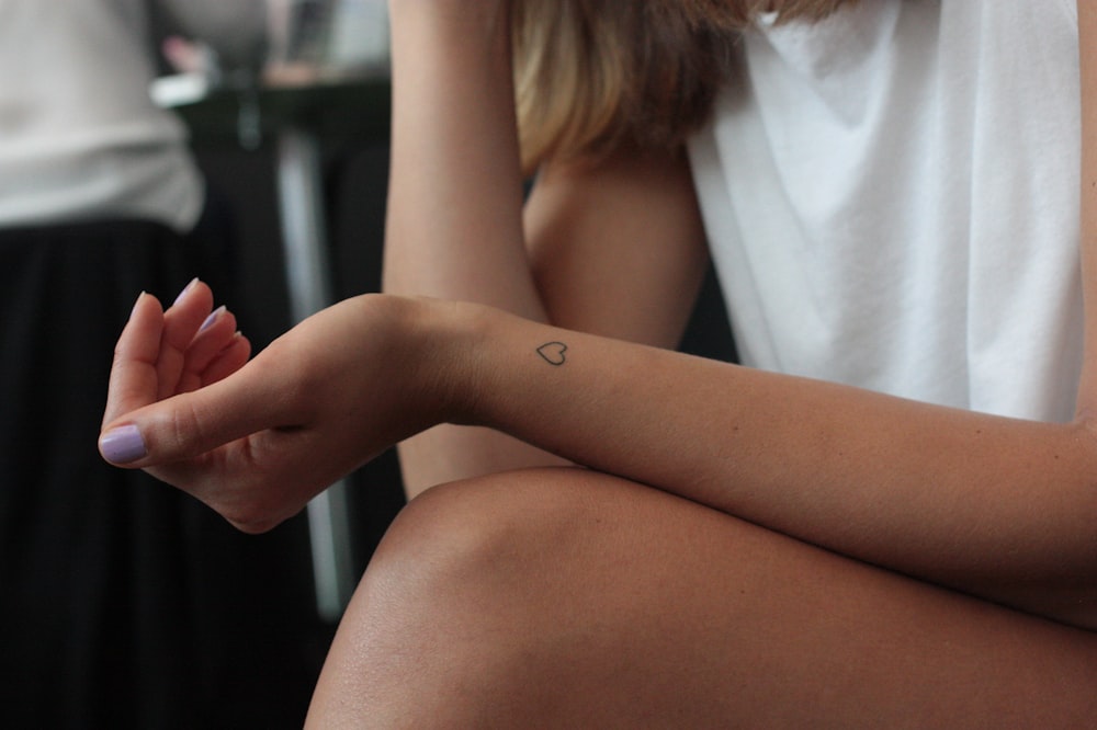donna che mostra il tatuaggio del polso a forma di cuore