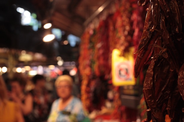 A rustic market stall displaying chiltepines, machaca, and coyotas with a warm sunlight glow.