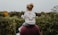 photo of girl riding on person shoulder