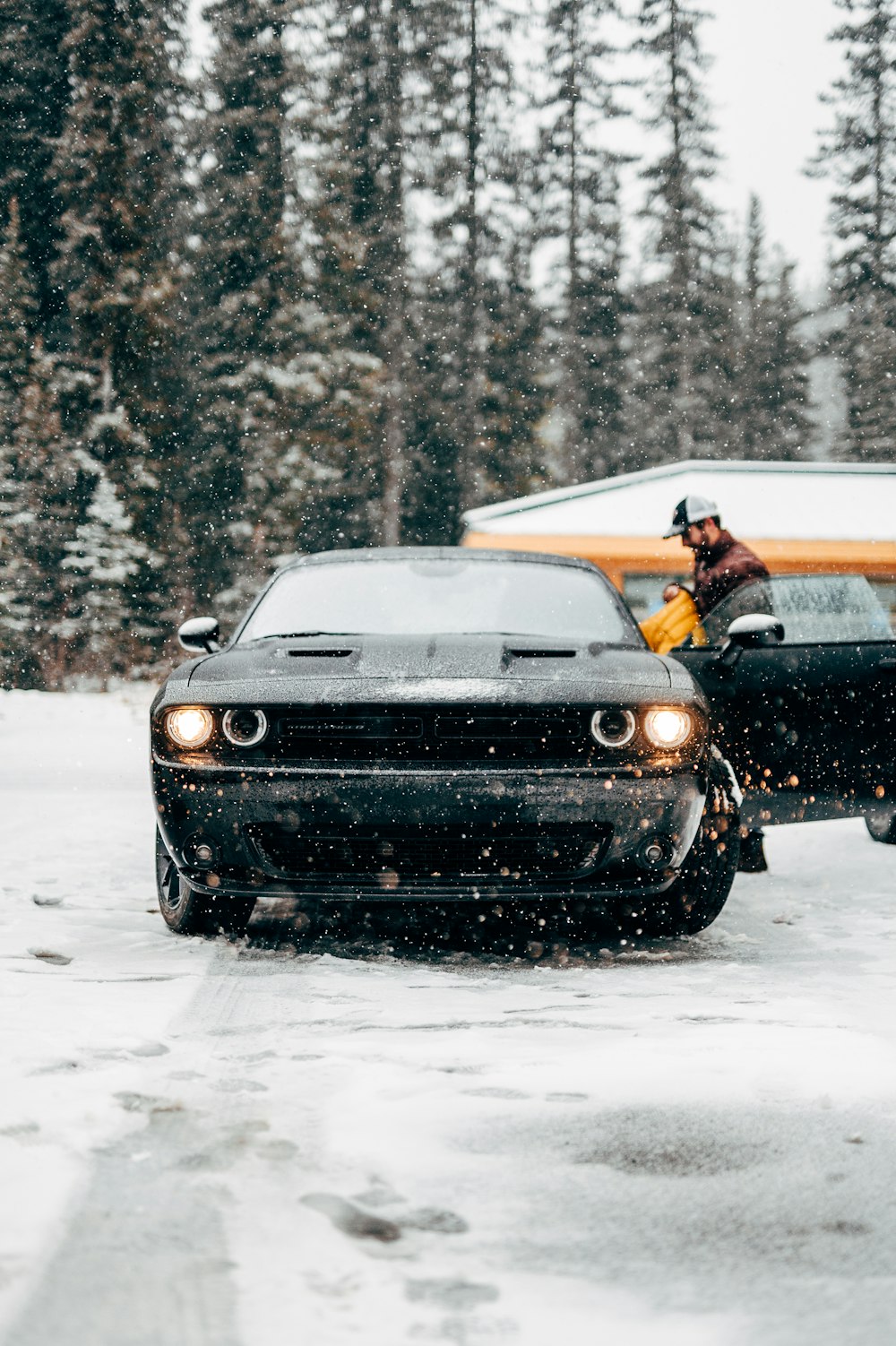 Foto de enfoque selectivo de una persona al lado del coche durante el invierno