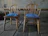 Photo of freshly upholstered farmhouse chairs in navy blue and lemon yellow fabric.