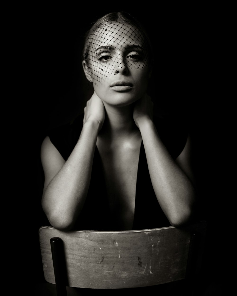 grayscale photo of woman sitting on chair