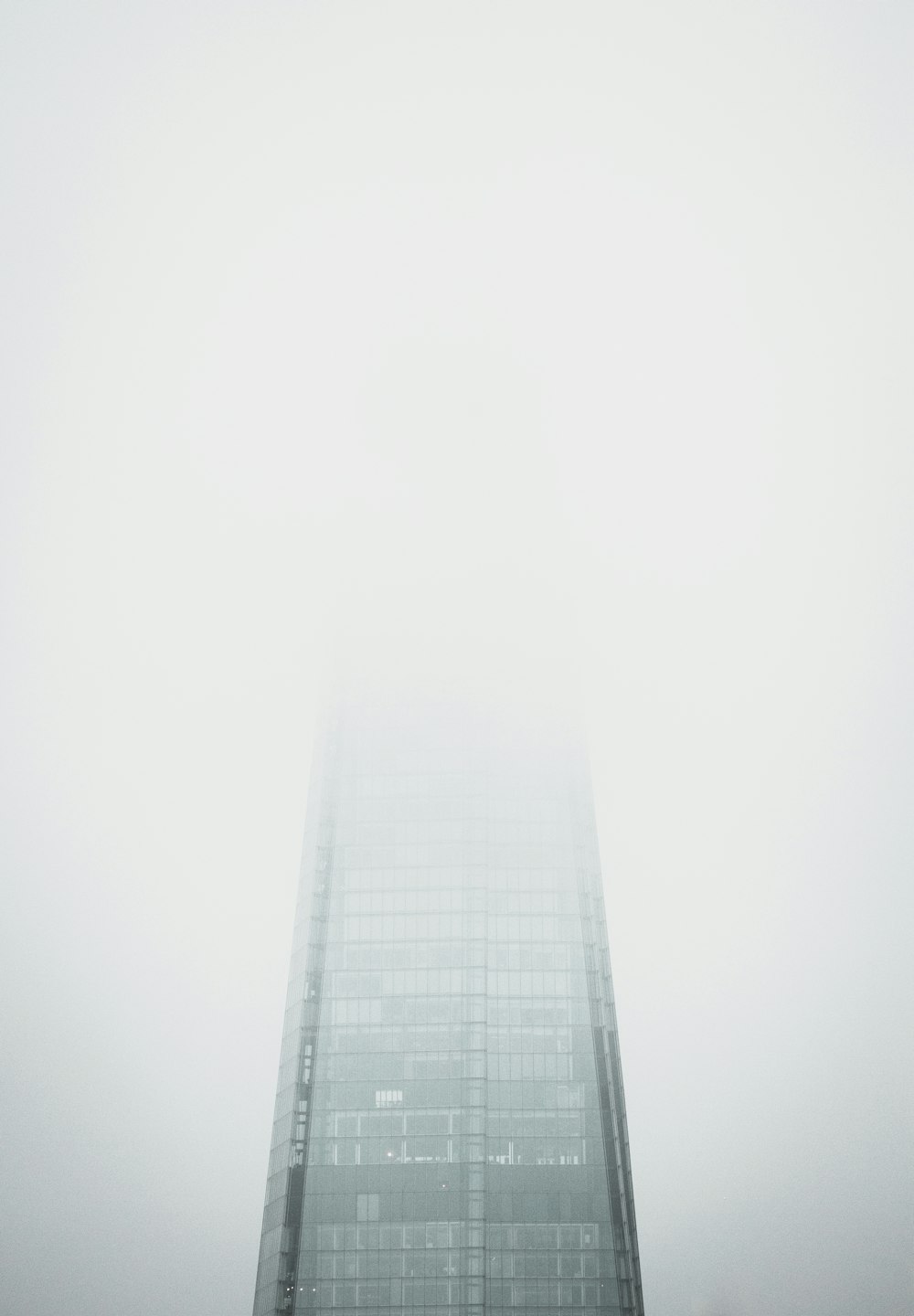 a tall building in the middle of a foggy sky