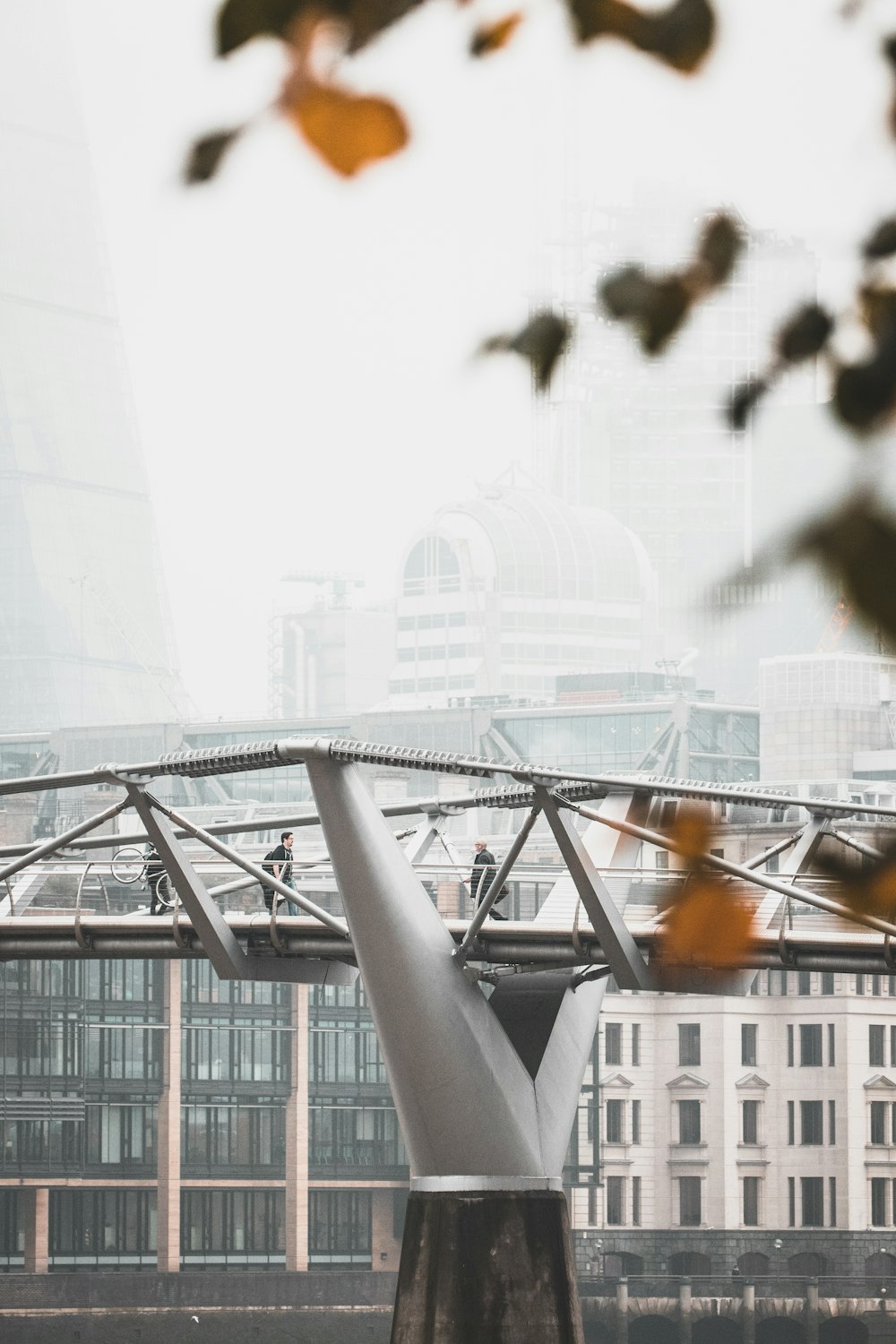 photo of man walking on gray bridge