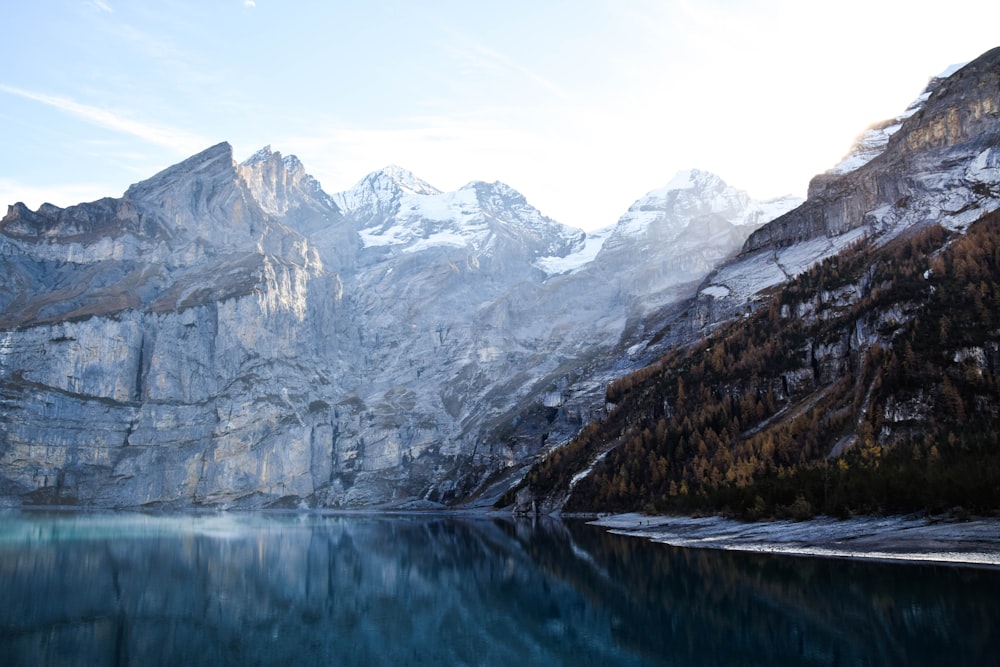 mountain covering with snow near body of water