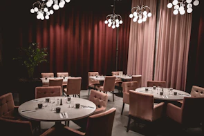 An elegant restaurant interior captured with soft ivory lighting and muted purple accents.