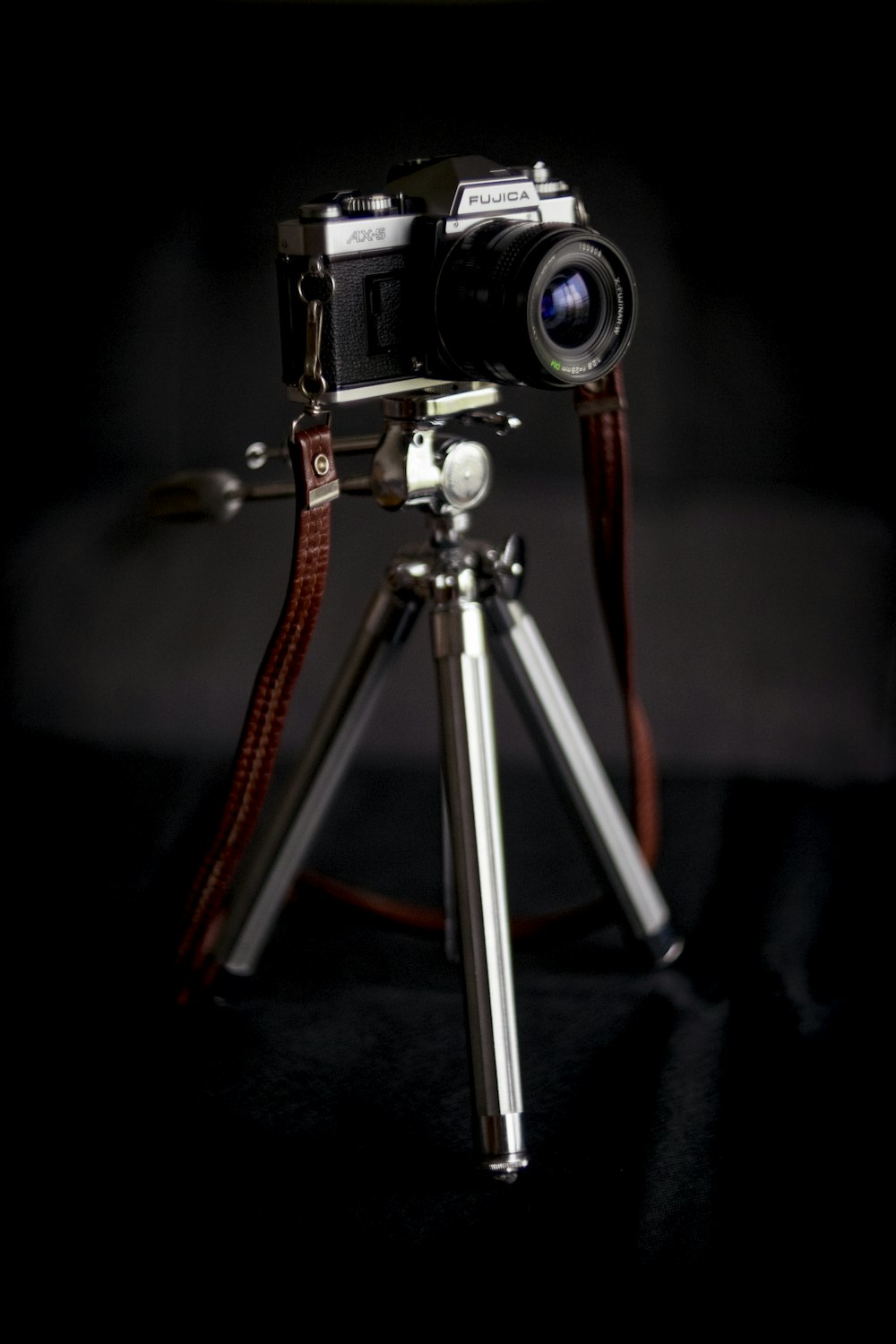 black and silver DSLR camera with tripod