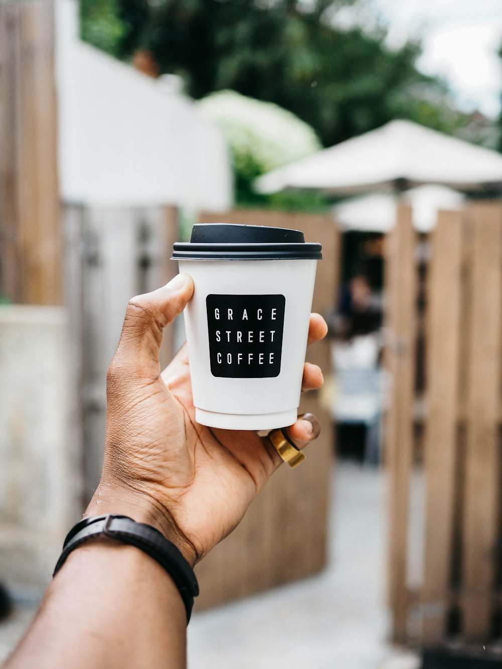 person holding white and black plastic cup