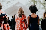 women's in red and white floral long-sleeved dress standing in front of stage