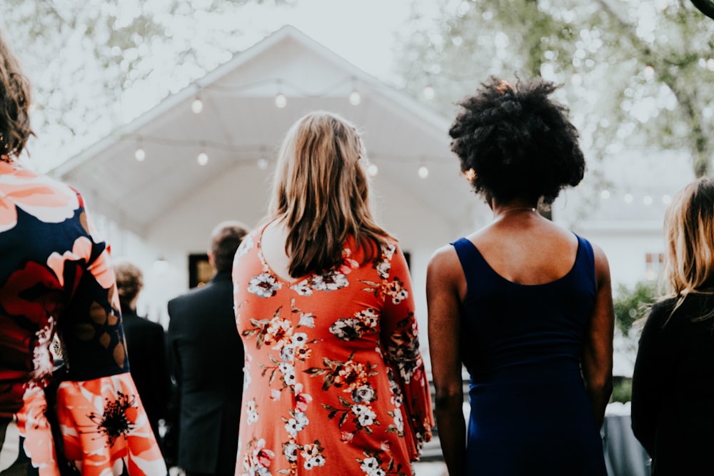 mulheres em vermelho e branco vestido floral de mangas compridas em pé na frente do palco