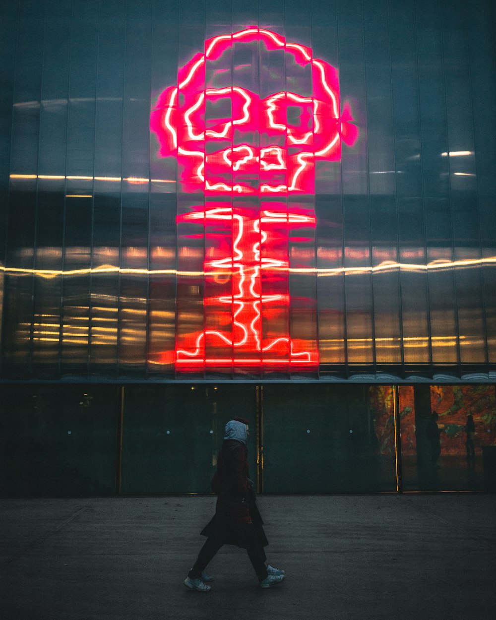 Persona con abrigo negro caminando durante la noche