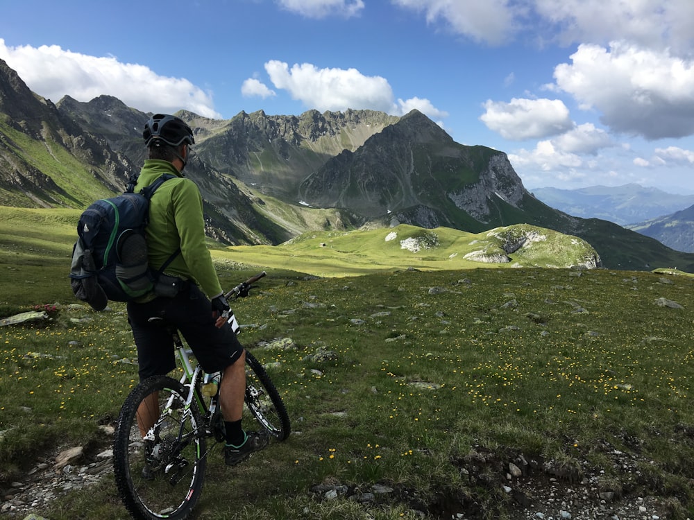 Uomo In Sella A Bicicletta In Cima Alla Montagna