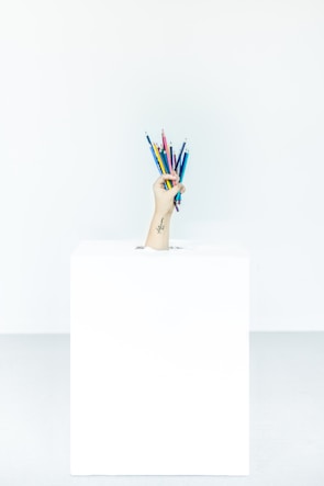 Close-up of a hand opening a small hidden box with a coupon inside, surrounded by urban street art.