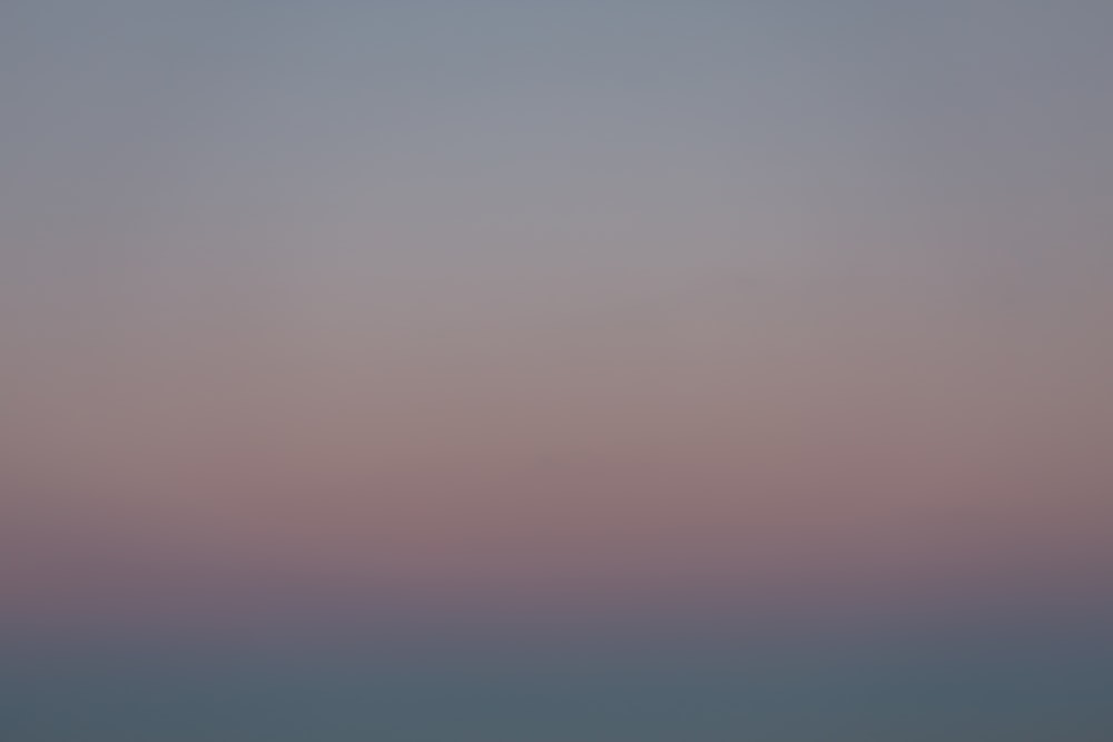 a plane flying in the sky at dusk