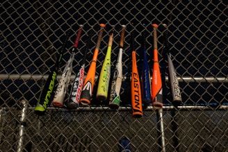 baseball bats hanged at the fence of the field
