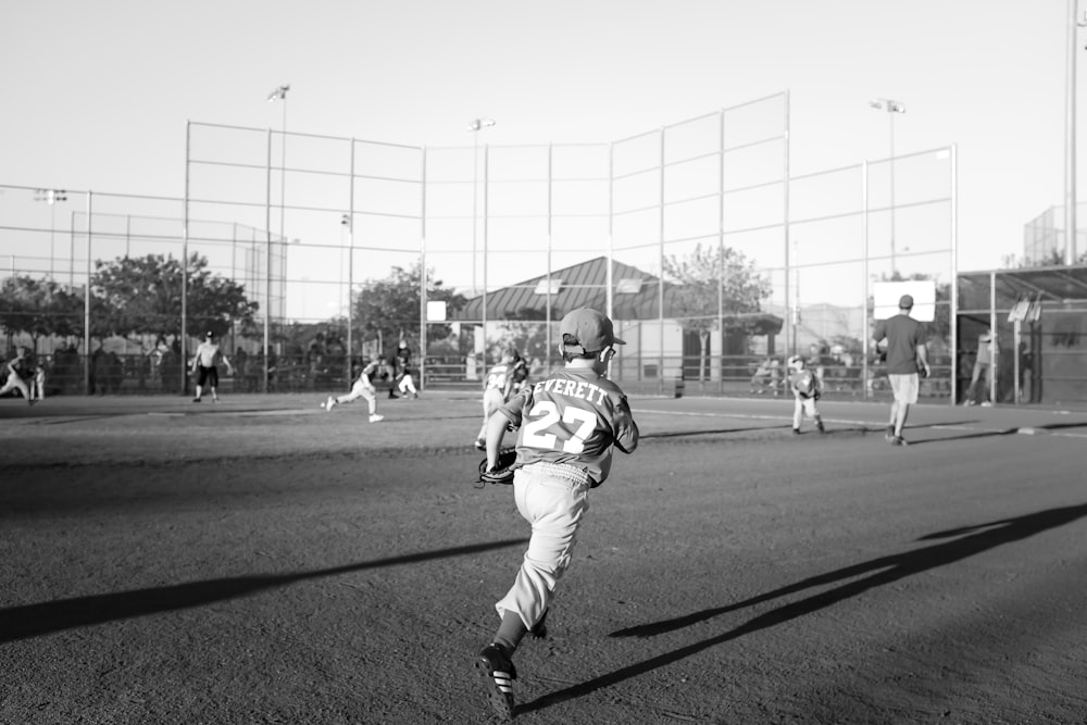 foto em tons de cinza de crianças jogando beisebol