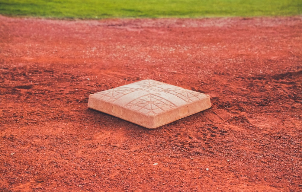 Base de baseball carrée en béton brun sur terre