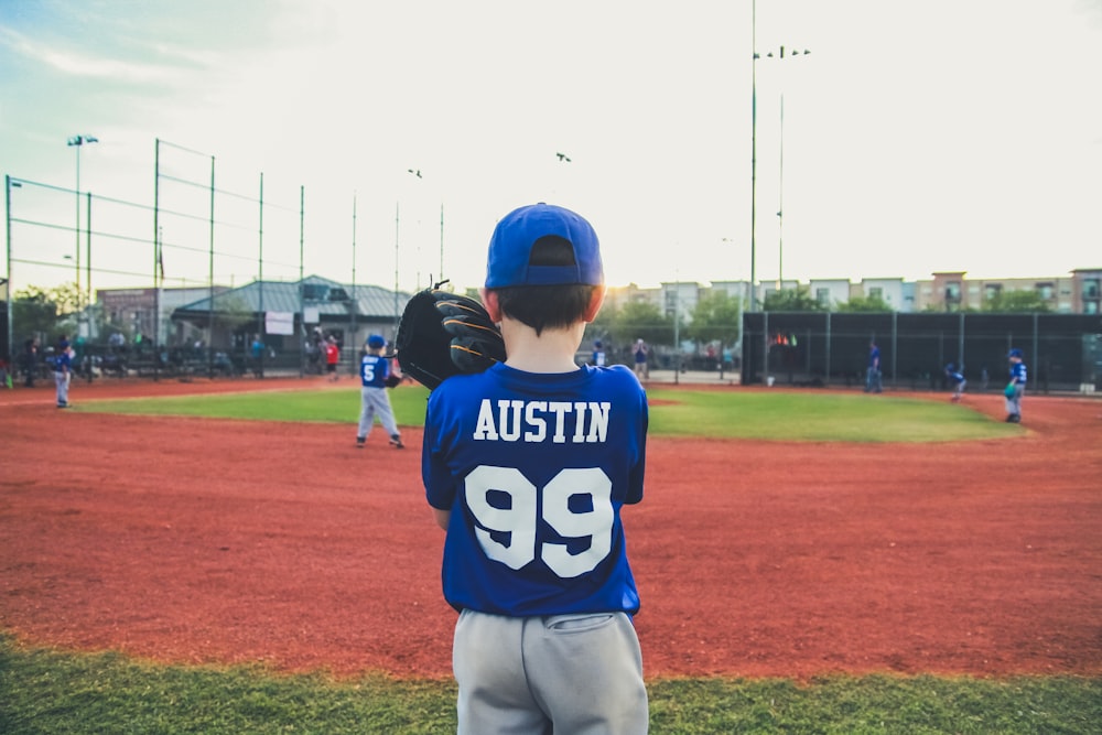 boy in blue and white shirt standing on green grass