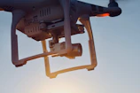 Close-up of a drone capturing aerial footage over a cityscape at sunset.