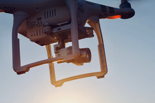 Close-up of a drone capturing aerial footage over a modern corporate building at sunset.