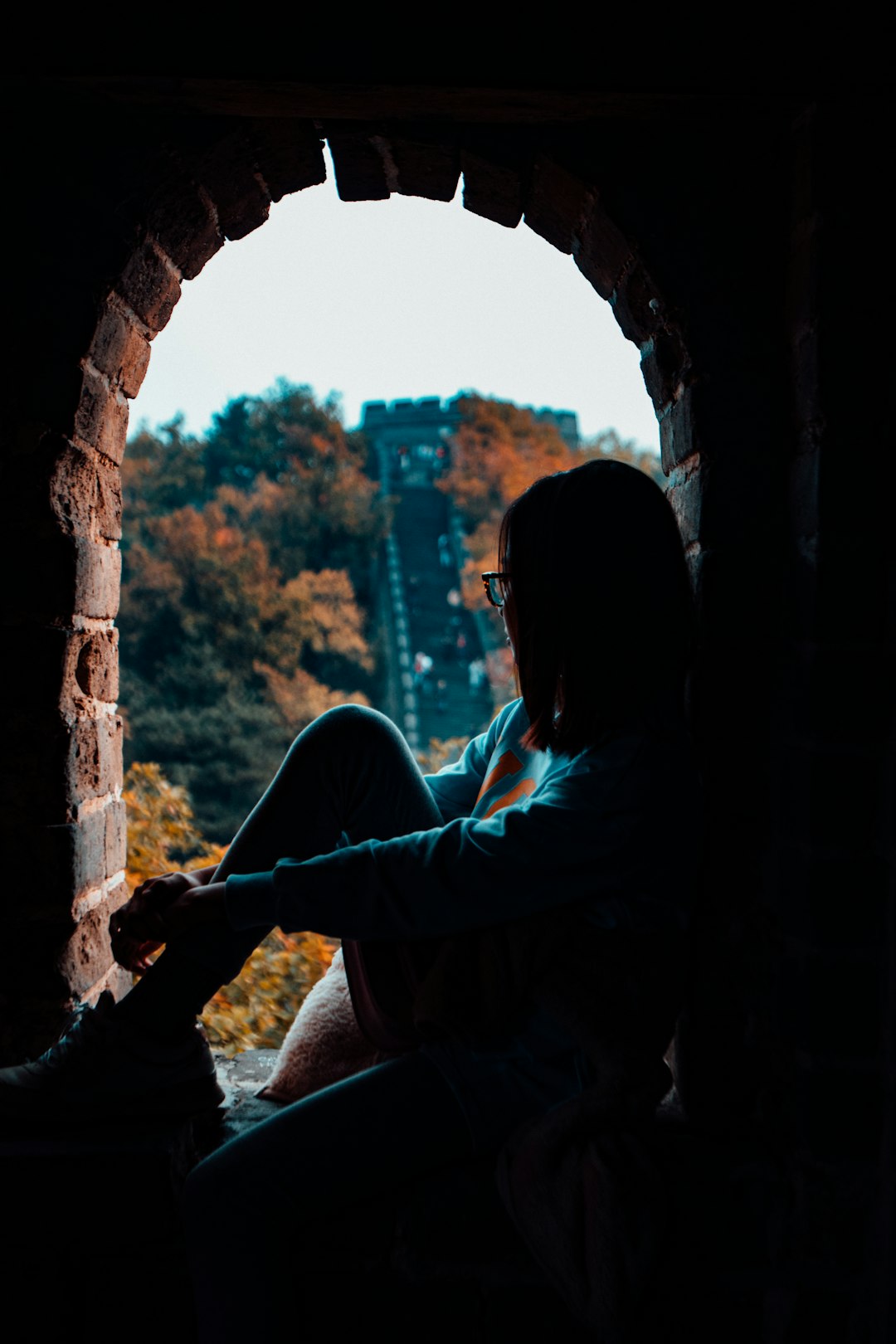 woman sitting on window arch during daytime