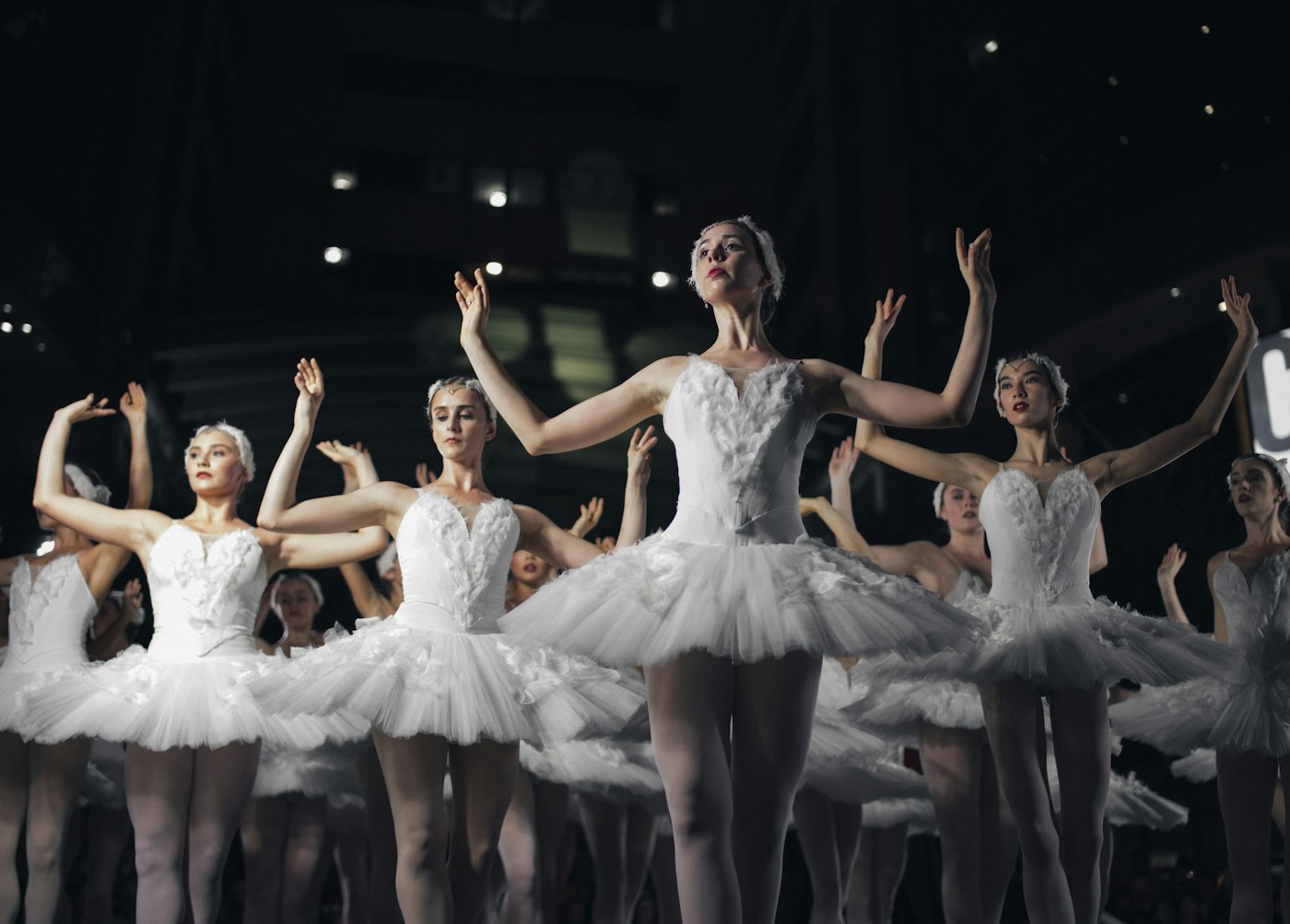Young ballerinas performing on stage during annual recital under spotlight