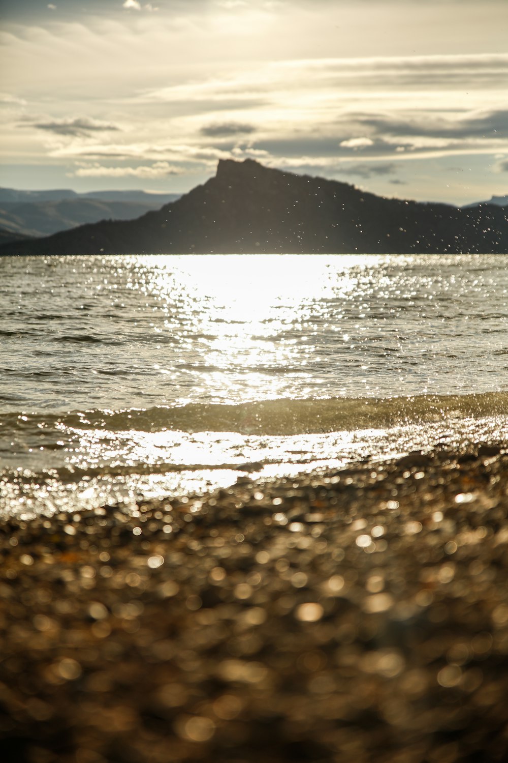 silhouette on mountain near body of water during faytime