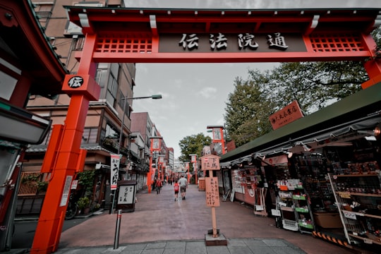 Kanji script text arch front of gray concrete pavement in Asakusa Japan