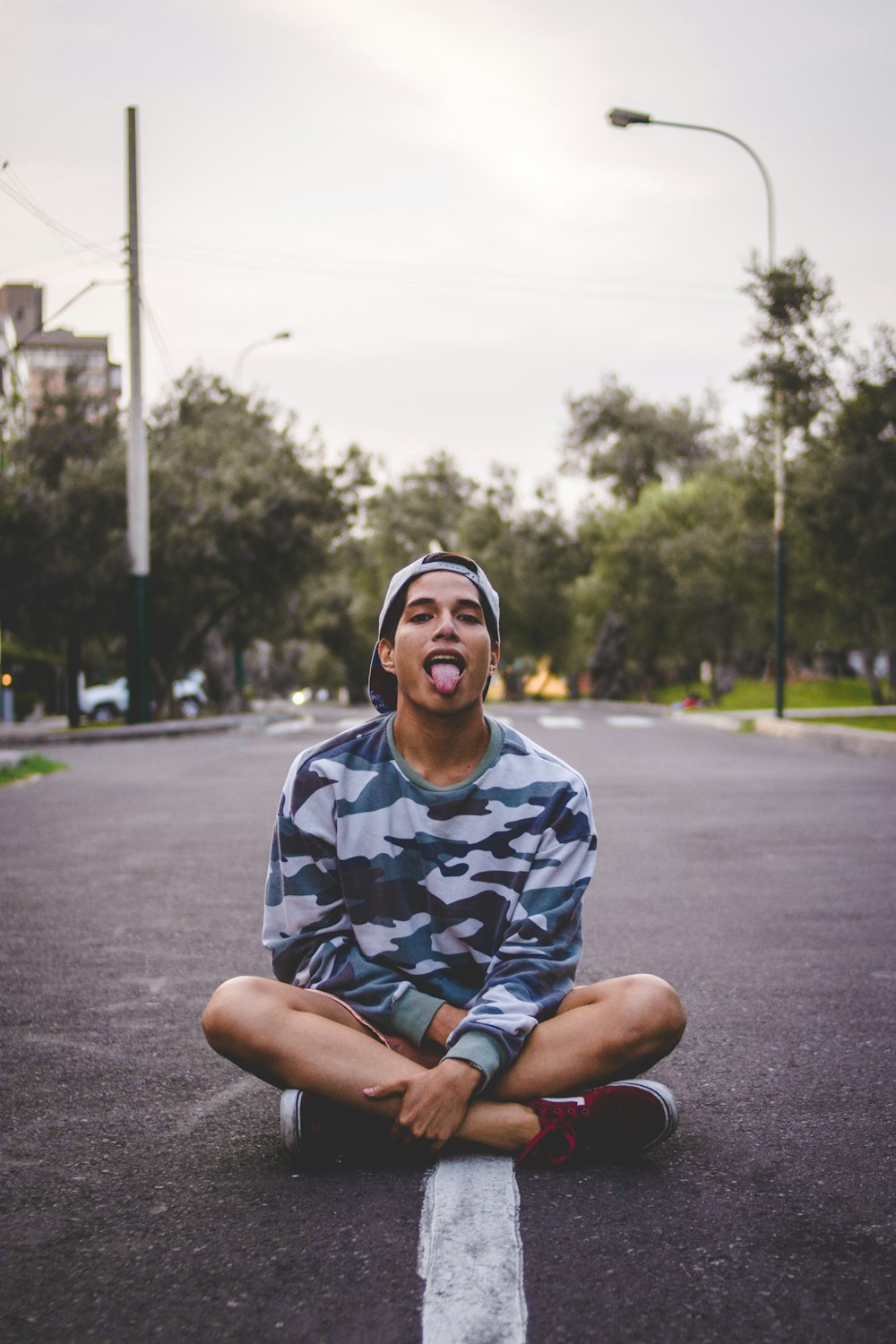 man sitting on asphalt road