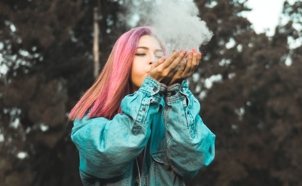 woman blowing powder off her hands