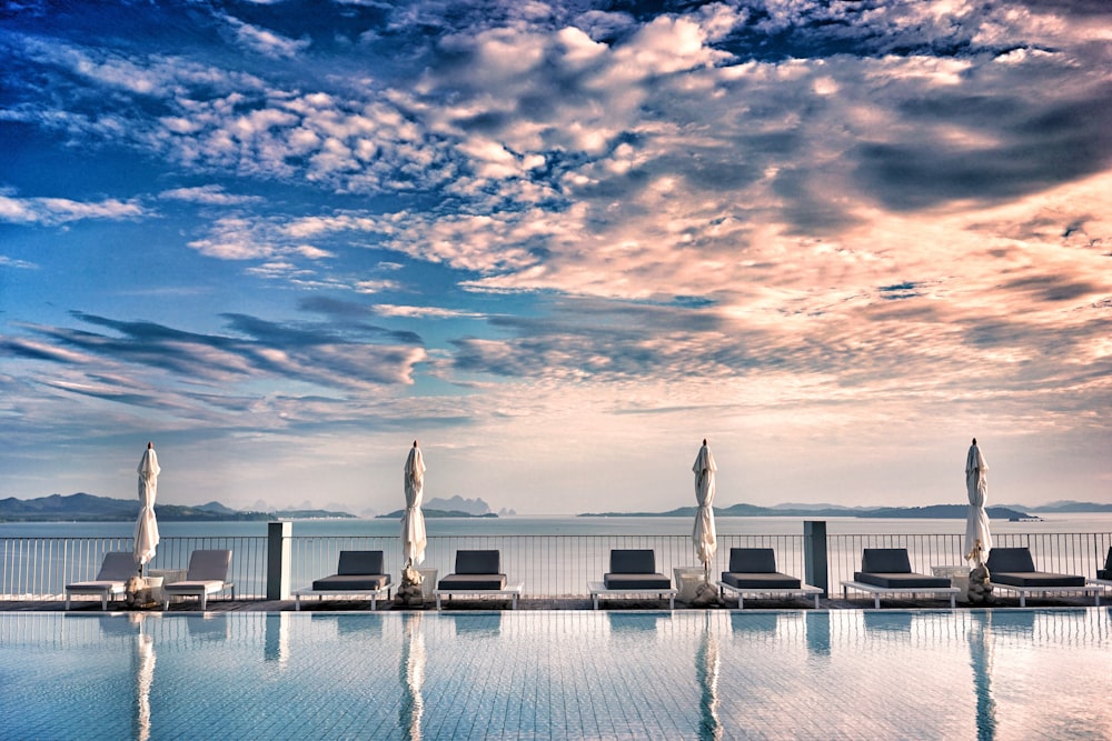 loungers near pool under gray clouds