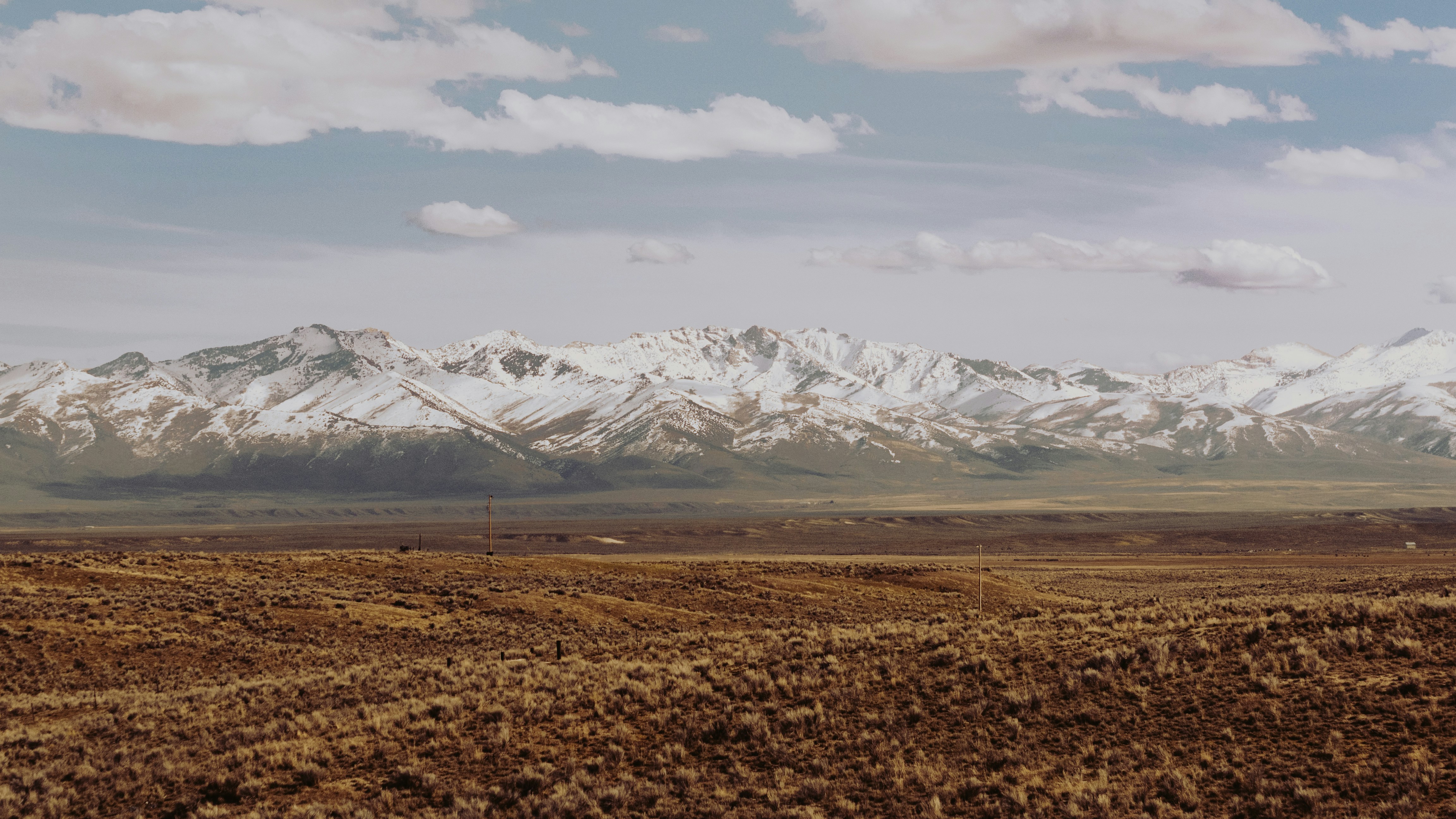 mountains covered with snow under gray clouds, Dwarfed by mountains either side, we travelled through between Reno and Salt Lake City.