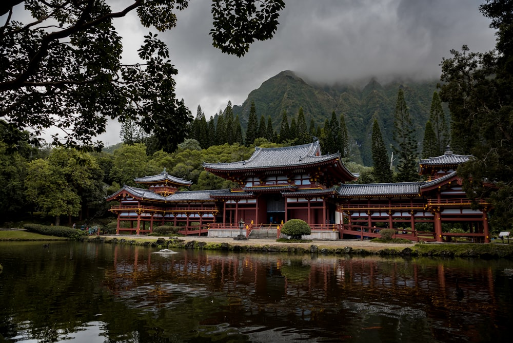 gray and brown pagoda temple beside calm body of water at daytime