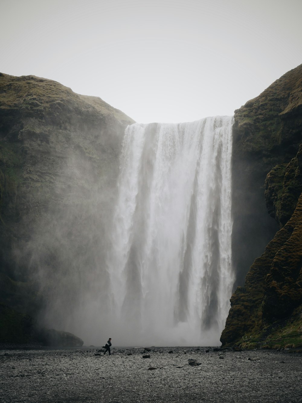 person standing near waterfalls