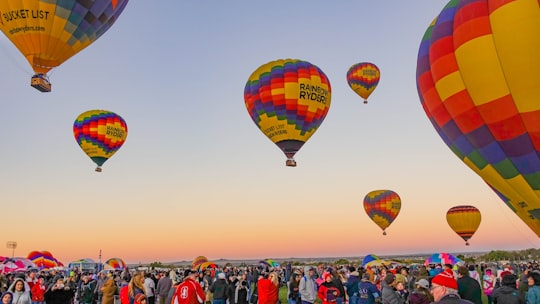 people gathering below multicolored hot air balloons in Albuquerque United States