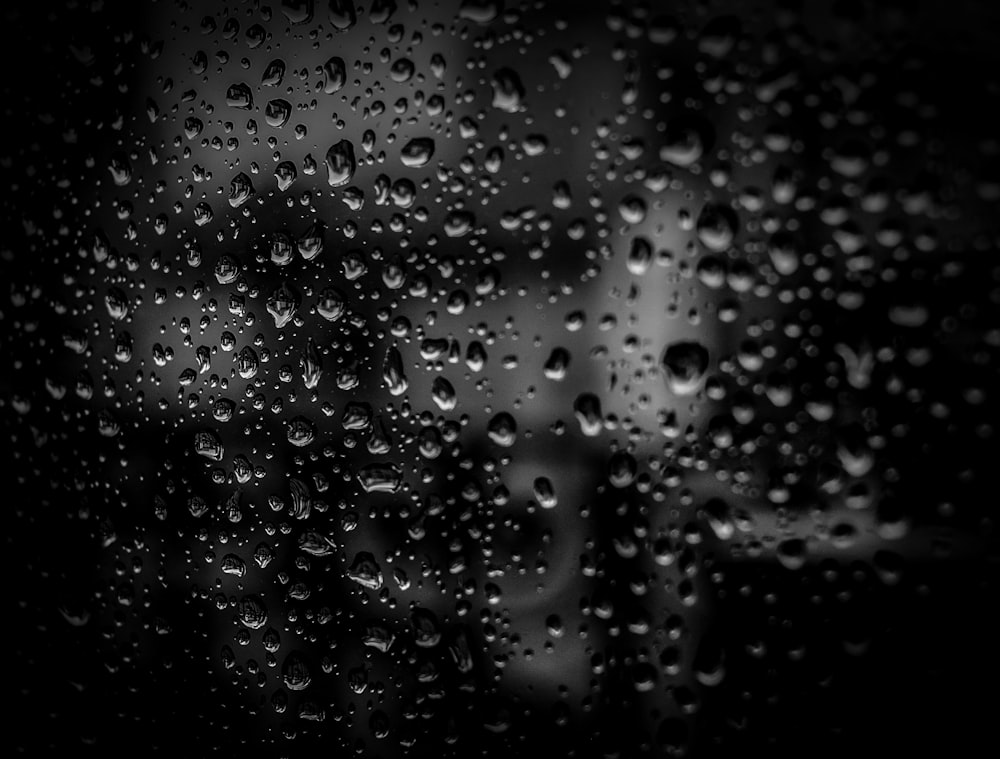 창문에 떨어지는 빗방울의 흑백 사진