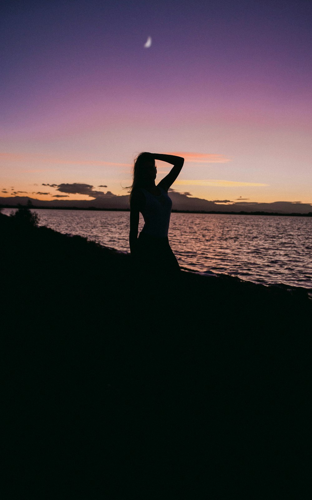 silhouette di donna in spiaggia con la mano sinistra sulla testa