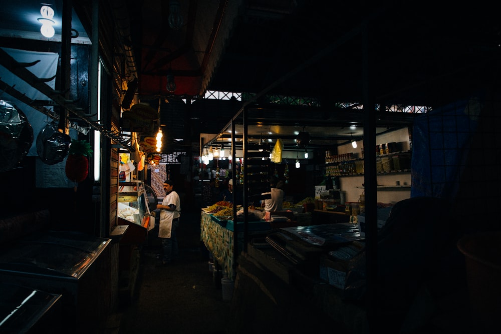 man in white shirt standing beside bdesk