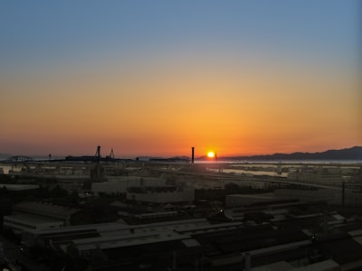 A vibrant image showcasing a bustling oil refinery at sunset.