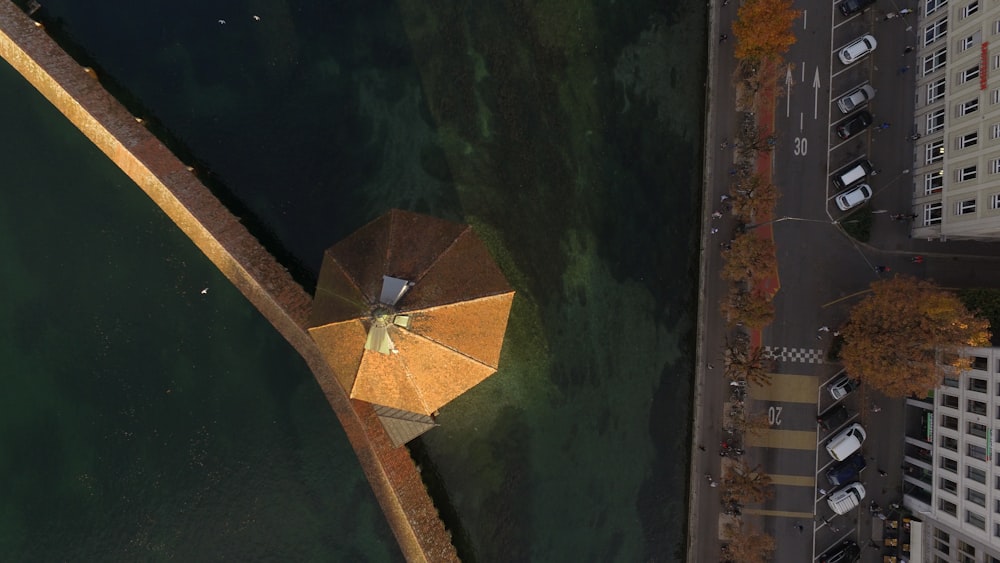 bird's eye view photography of brown roof on body of water