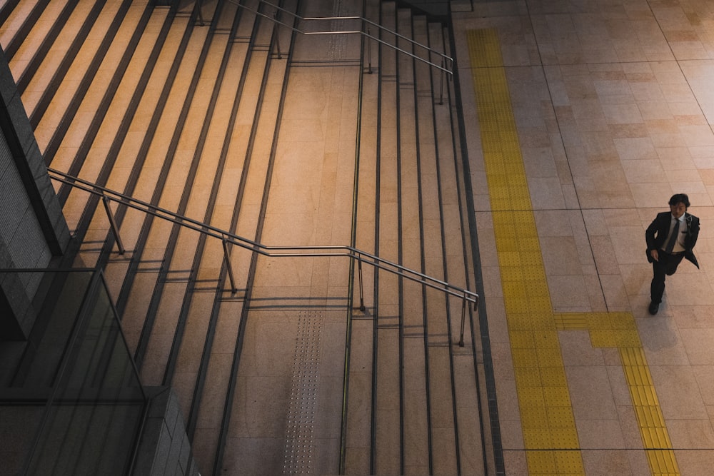 man walking in front of grey steel stair railing