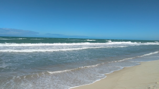A serene beach with gentle waves lapping at the shore.