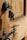 A close-up view of a wooden door with a metal lock and keys hanging from it. The keys are inserted into the lock, and the metal latch on the door is visible.