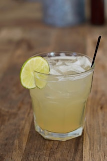 Refreshing tropical fruit juice served in a glass with ice and a slice of lime on the rim
