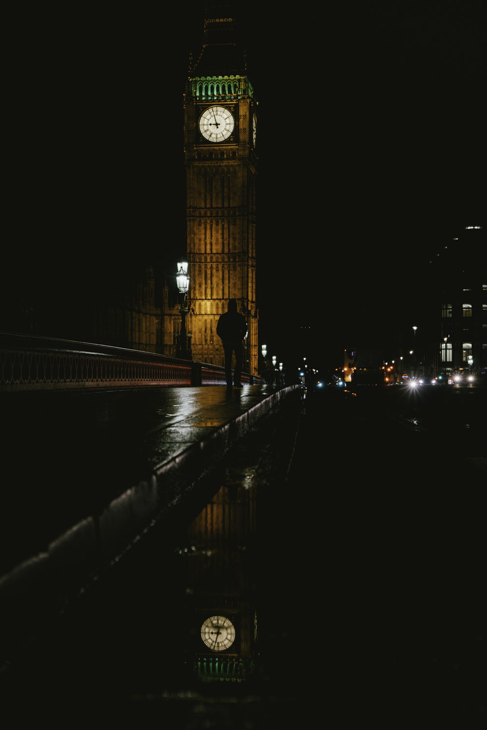 Silhouettenfoto eines Mannes, der nachts in der Nähe von Big Ben spazieren geht