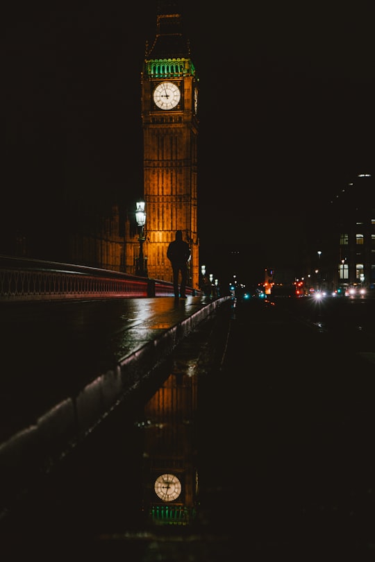 silhouette photo of man walking near Big Ben during nighttime in Big Ben United Kingdom