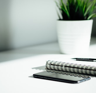 pen, notebook, and smartphone on a clean white table 