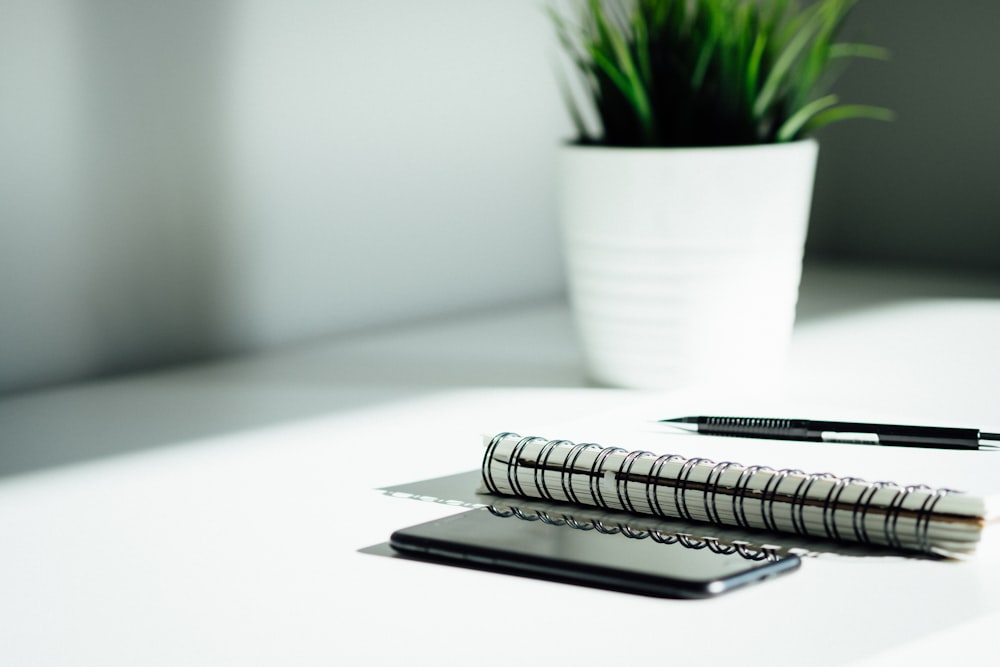 pen, notebook, and smartphone on table